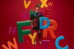 Woman with amputated leg behind colorful alphabets