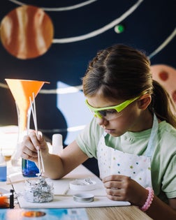 Girl doing scientific experiment at table