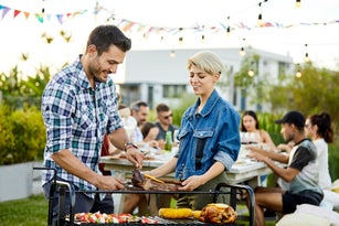 Male serving meat to friend during Asado
