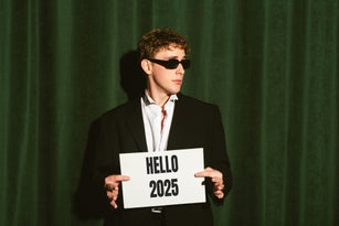 Young man holds a 2025 small banner