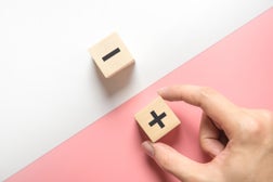 Pros and cons concept, Hand choose wood blog with plus and minus on white and pink background.