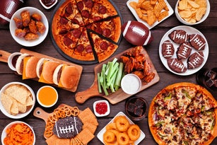Super Bowl or football theme food table scene, overhead view on dark wood
