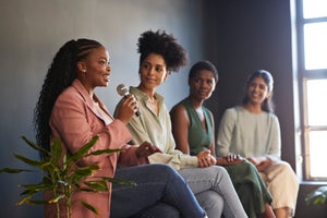 Colleagues listening to confident businesswoman during discussion