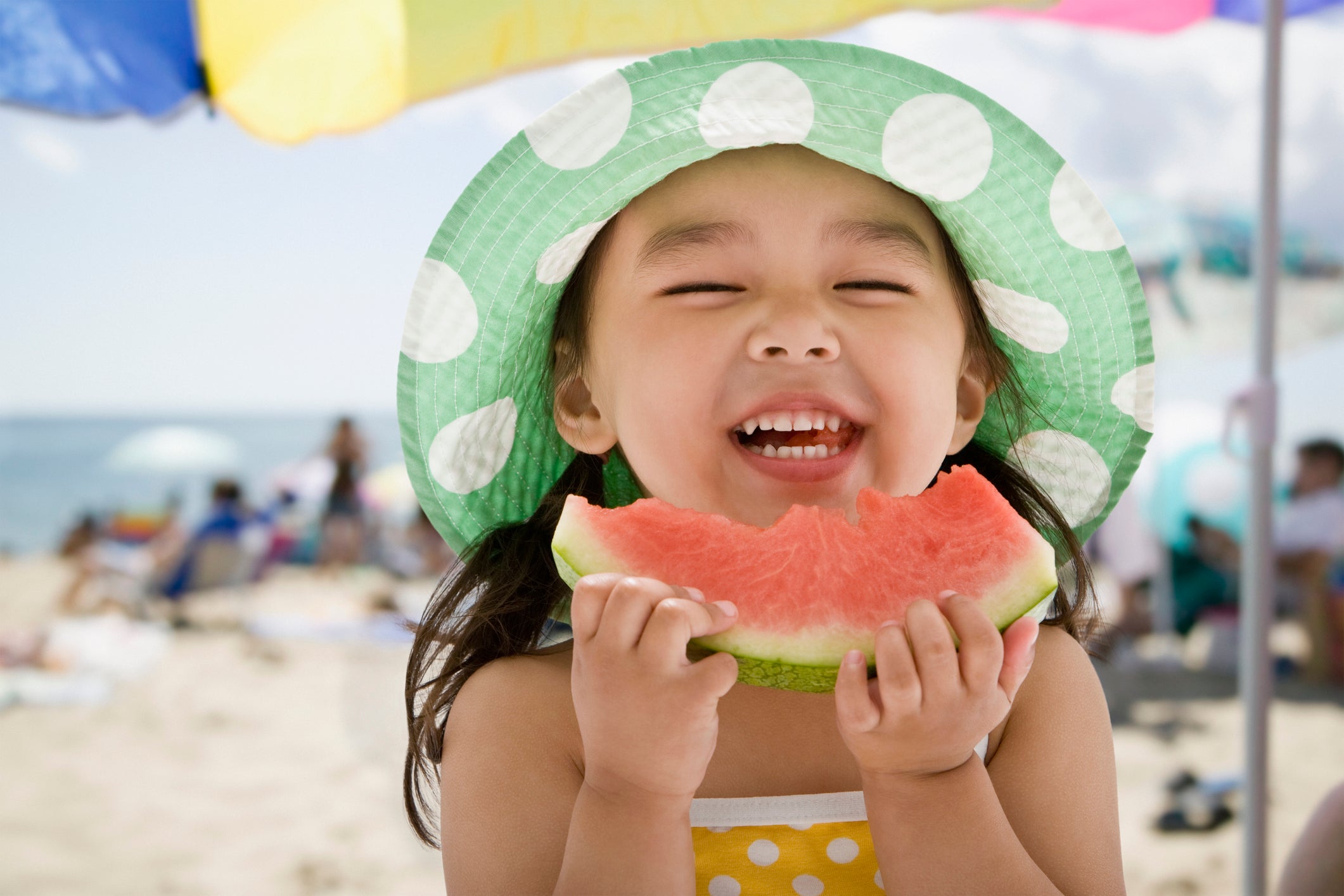 Asian girl eating watermelon at beach