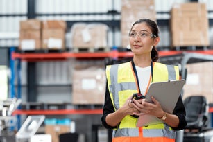 Portrait of Female Warehouse Supervisor working in leading distribution warehouse. She having skilled in audit daily operations, while controlling and managing inventory and logistics.