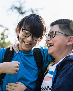 School age brothers laughing outdoors