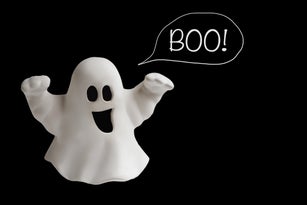 Funny white ghost doing boo gesture on black background. Halloween greeting card