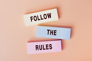 Follow The Rules. Concept of text on color cards. Top view image of cards and on pastel beige background. Flat lay design