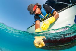 Marine Biologist taking samples of water from a boat for water quality test