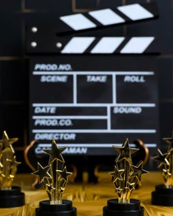 Movie-film clapboard and gold-star award trophies