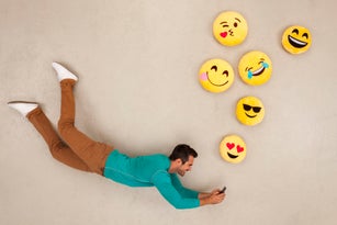 Man chatting on his smart phone, sending emojies