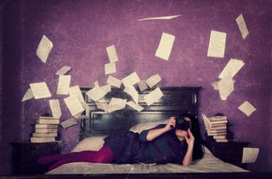 Woman photographing loose sheets of a book, flying around her