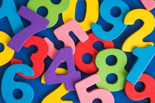 Close up of multicolored wooden numbers back to school abstract.