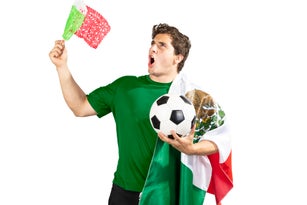 Young man with a soccer ball and a mexican flag after Shouting of emotion.