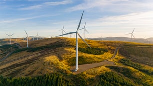 A drone/aerial view of a wind farm on a hilltop in Scotland