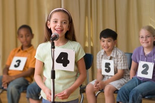Hispanic girl giving answer in spelling bee