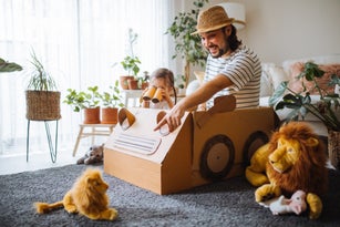 Daughter and father are on safari at home with a handmade cartoncar