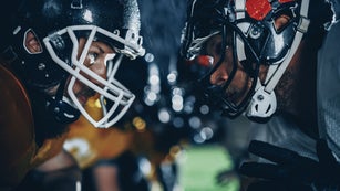 American Football Game Start Teams Ready: Close-up Portrait of Two Professional Players, Aggressive Face-off. Competition Full of Brutal Energy, Power, Skill. Rainy Night with Dramatic Light