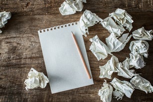 White square paper, pencil and wasted papers on wooden back ground