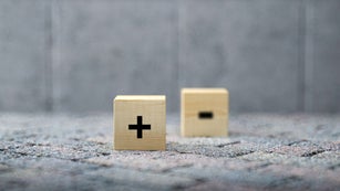 Plus and minus icons on wooden cubes with focus to the Plus"n - 3d illustration