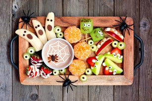 Tray of healthy Halloween fruit snacks, top view over a rustic wood background