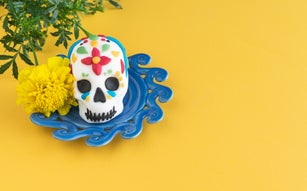 Day of the Dead. Colorfully decorated skull on yellow background. Copy space.