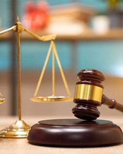 Business and lawyers discussing contract papers with brass scale on desk in office. Law, legal services, advice, justice and law concept picture with film grain effect