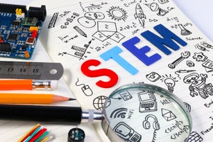 STEM concept with drawing background. Magnifying glass over education background.