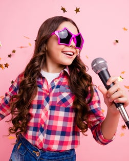 Close up photo of cool attractive crazy lady kid have fun visit event future musician loud voice solo hold hand free time stylish checked shirt isolated over pink background long haircut hairdo
