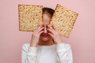 Young girl holding matzah or matza. Jewish holidays Passover invitation or greeting card.