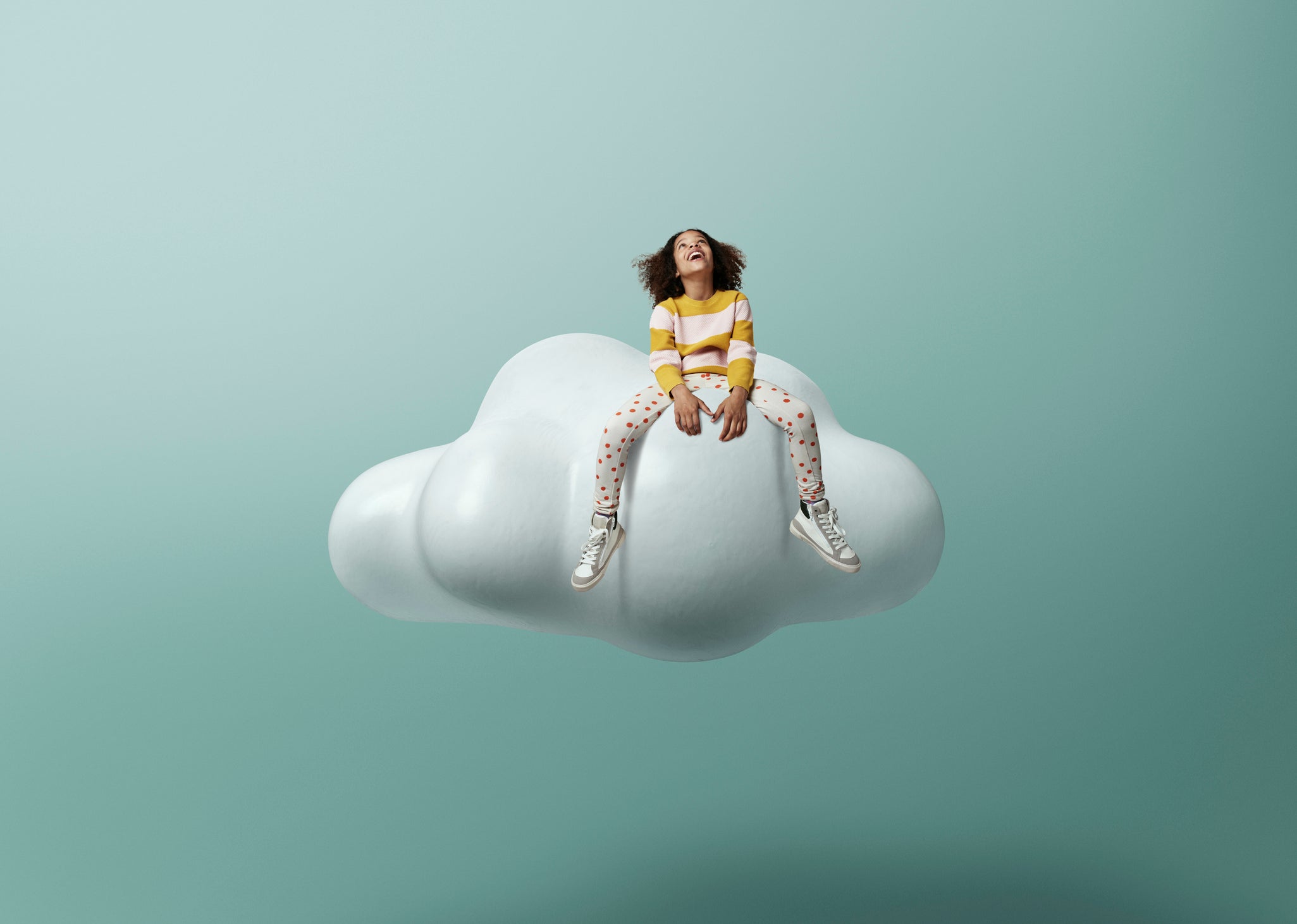 Girl laughing while sitting on cloud