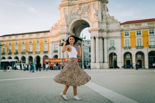Happy young woman dancing in the city, Lisbon, Portugal