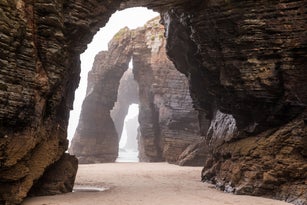 Natural rock arches on Cathedrals beach in low tide, Spain