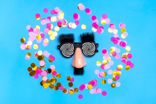 funny face - fake eyeglasses, nose and mustache, confetti, sequins on blue background Happy fools day concept 1st April party Holiday card
