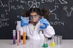 surprised scientist girl with gloves in lab coat