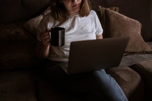 Young Woman Using Laptop On The Couch