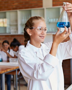 School girl holding up beacon with blue liquid
