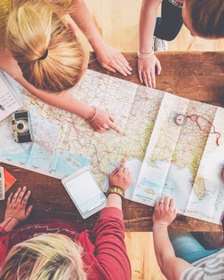 Caucasian women planning trip with map on wooden table