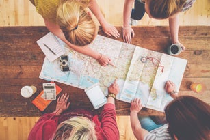 Caucasian women planning trip with map on wooden table
