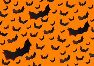 Image of a large group of handmade black bats made of paper on a plain orange background. Halloween concept.