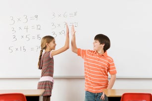 Students high-fiving after completing math at whiteboard