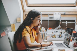hispanic young woman working and studying from home using laptop