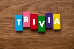 A colorful wooden block with text Trivia on wooden background.