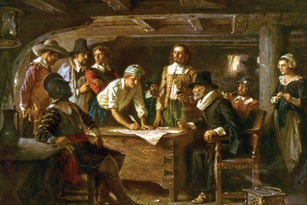 A group of people gathered around a table looking at a document.