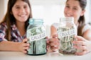 Caucasian twin sisters saving for college