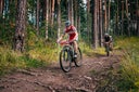 three bikers in the mountains by downhill