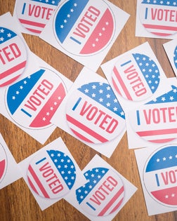 Multiple I Voted stickers on table - concept of voter fraud showing many I voted stickers.