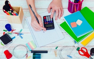 schoolgirl on math lesson checking the result on calculator