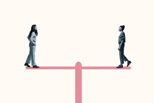 Young women standing on equal-arm balance