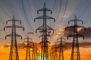 High voltage towers at sunset background. Power lines against the sky